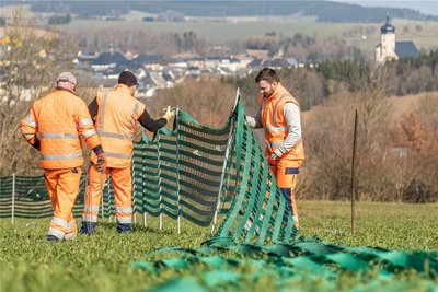 Mitarbeiter der Straßenmeister Zöblitz bauen an der B 174 den Schneezaun ab. Die Meisterei hatte davon insgesamt 7200 Meter errichtet.