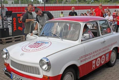 Trabant Erwin sorgte gleich bei seinem ersten öffentlichen Auftritt beim FSV Zwickau im Juni 2024 für viel Freude, unter anderem bei Trainer Rico Schmitt (hinten links) und Sportdirektor Robin Lenk.