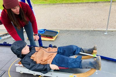 Karl aus der Gruppe der „Wirbelwinde“ der Bewegungskita in Bad Schlema traute sich als Erster zur „Trockenübung“ in den Rennrodelbob. Unter Anleitung von Kadersportlerin Melina Fischer (19) brachte sich der Junge in die richtige Position. Durch den Eiskanal geht es nämlich liegend.