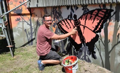 André Wolf aus Kürbitz hat die Stützmauer zum Bahndamm hin im Freizeitgelände am Kreisverkehr in Lengenfeld mit Schmetterlingen und Blumen besprüht. 