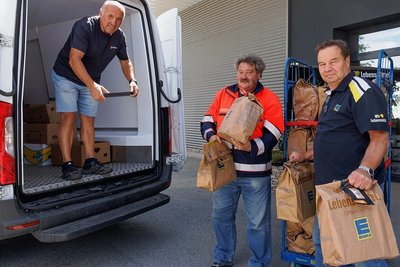 Wolfgang Hahnel und Mirko Hechsman von der Annaberg-Buchholzer Tafel des Malteser Hilfsdiensts haben bei Edeka-Marktchef Frank Küllig (von links) in Oberwiesenthal Spendentüten von Kunden abgeholt. 