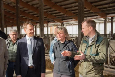 Sachsens Ministerpräsident Michael Kretschmer im Hofgut Eichigt mit Geschäftsführer Jannis Buschtöns (rechts) und Aneka Meinel, Leiterin der Tierhaltung.