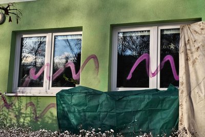 Teile der beschmierten Fassade wurden mit Decken und Planen notdürftig verdeckt.
