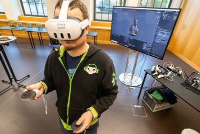 Sven Winkler vom Studiengang Maschinenbau demonstriert mit Hilfe einer VR-Brille die Digitalisierung von Kunstwerken der TU.
