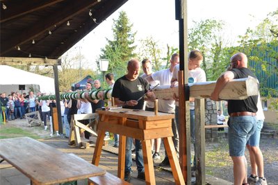 Vor dem Aufstellen wird der Maibaum am Unterstand befestigt.