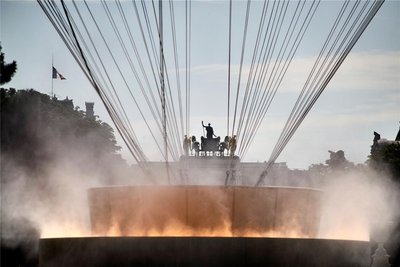 Erst aus der Nähe ist es zu erkennen: Das olympische Feuer ist gar keines. Es handelt sich um eine Installation mit 40 LED-Scheinwerfern, die das aus etwa 200 Düsen gespritzte Wasser in Form von Wasserdampf beleuchten.