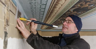 Restaurator Volkmar Voigt arbeitet im zweiten Obergeschoss des Lotterhofs. Die teilweise vorgefundene Originalbemalung erlaubte es ihm, neue Schablonen anzufertigen. Nun wird Detail für Detail wieder aufgebracht.
