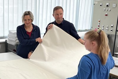 In der Wäscherei der Werkstatt nahm sich Marcus Köppler (M.) auch die Zeit, zusammen mit Praktikantin Annika Renatus, Jana Leischker (l.) kurz einzuarbeiten.