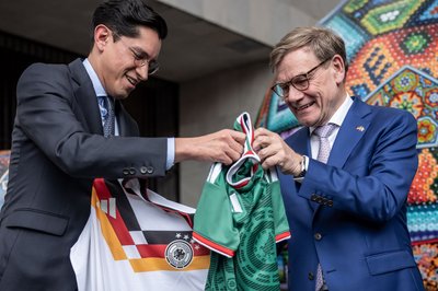 Außenminister Wadephul (rechts) nimmt ein Trikot der mexikanischen Fußball-Nationalmannschaft entgegen.