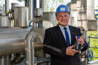 René Stahlschmidt von CAC Engineering hält an der Freiberger Demonstrationsanlage eine Flasche mit synthetischem Benzin in der Hand.
