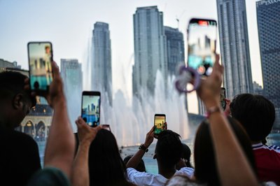 Eid al-Adha in Dubai: Besucher fotografieren den Brunnen vor der Skyline