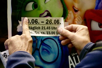 Andreas Osse klebt im Autokino Langenhessen das Datum der kommenden Spielwoche über ein Filmplakat.