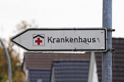 Ein Hinweisschild mit der Aufschrift „Krankenhaus“ weist an einer Straße den Weg zu einer Klinik.