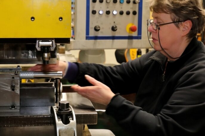 10.000 Produkte im Portfolio -Firma auf Kurzrohre spezialisiert - Mitarbeiterin Sylvia Dichte an einer Presse, mit deren Hilfe die gestanzten und zugeschnittenen Metalle zu Rohren geformt werden. 