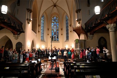 Vor dem Altarraum der Christuskirche in Freital stehen 50 Männer und Frauen: Probe für das Oratorium „Rut“ in Freital vor der Uraufführung am 23. September 2023.