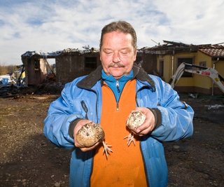 Den Brand im Stall (hinten) haben zwei Wachteln unbeschadet überstanden. Besitzer Olaf Höppner zeigt die beiden Überlebenskünstler.