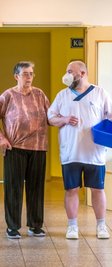 Auch das gehört zum täglichen Programm: Pfleger Roy Neubert begleitet eine Bewohnerin ins Bad.