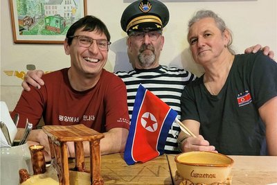 Prellbock-Betreiber Matthias Lehmann (Mitte, mit südkoreanischer Bahnermütze) hatte am Samstag Dirk Wachler (li.) und Dierk Minkner zu Gast. Sie berichteten über ihre Reise nach Nordkorea. 
