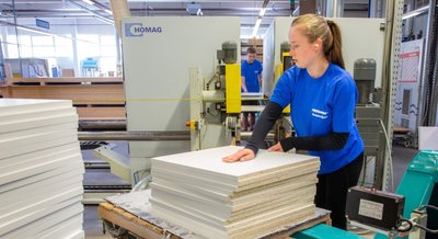 Esther Kaden (vorn) und Armin Witte gehören zu den drei jungen Leuten, die zurzeit in der Ratiomat Einbauküchen GmbH Leubsdorf einen Ferienjob ausüben. Die Bearbeitung von Bauteilen an einer Kantenbearbeitungsmaschine gehört zu den Tätigkeiten für die Schüler. 