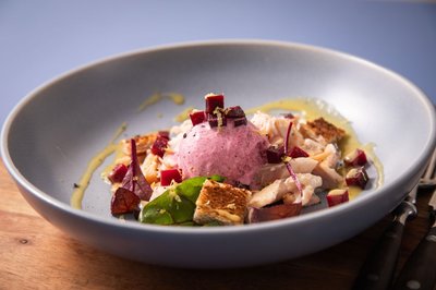 Sieht aus wie Erdbeereis - ist es aber nicht. Auf dem Teller wurde Rote Bete-Eis auf geräucherter Forelle mit Rote Bete-Würfeln, Blattsalaten, Toastwürfel und einer Vinaigrette angerichtet.
