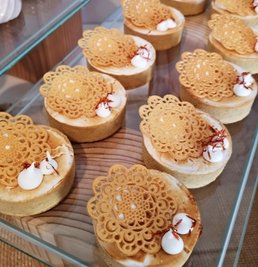 Tartelettes aus goldener Milch mit Kurkuma, Ingwer und Zimt, mit Spitzendeckeln aus weißer Schokolade.