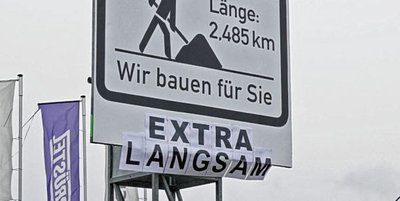 Die Bautafel an der B 180 hat eine Ergänzung von frustrierten Scherzbolden erhalten.