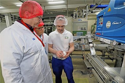 René Flath (r.) erläutert die Verpackungstechnik in der Molkerei. 