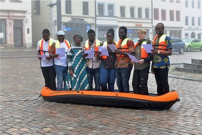 Sechs Studenten aus Ghana und Nigeria, verstärkt von Dozentin Ramatu Leeder-Kamanda (3. v.l.) und Stadträtin Jana Pinka (Die Linke, 7. v. l.), sangen auf dem Obermarkt in Freiberg die Ode an die Freude. Die Aktion des Konzeptkünstlers Shannon Alexander Murphy soll für Hoffnung und Verständigung stehen. 