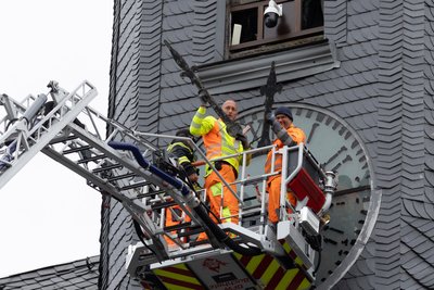 Mit Unterstützung der Feuerwehr haben Bauhofmitarbeiter die Zeiger der Annaberger Rathausuhr abmontiert.