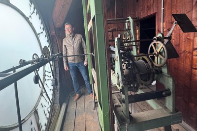 Hauptamtsleiter Holger Trautmann im Rathausturm hinter dem gläsernen Ziffernblatt, wo sich das Uhrenwerk befindet.
