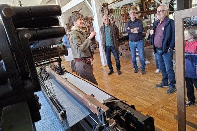 Leiterin Cornelia Hilsberg erklärt den Besuchern in der Schauweberei Braunsdorf die historischen Maschinen.