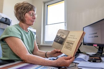 100 Jahre „Lebensbaum“: Warum dieser Kindergarten Burgstädter seit Generationen begleitet - Gabi Reinhold blättert in einer historischen Chronik des evangelischen Kindergartens „Lebensbaum“. Die Einrichtung in Burgstädt feiert in diesem Jahr ihr 100-jähriges Bestehen.