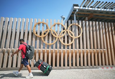 Ein Mann vom Team Mexiko geht an Olympischen Ringen am Eingang vom Olympic Village vorbei. Das olympische Dorf ist eine Wohnsiedlung, in der die Teilnehmer der Olympischen Spiele 2020 untergebracht sind.