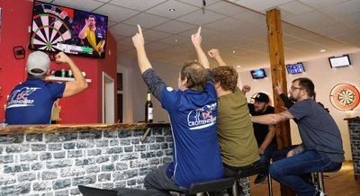 Thomas Löser, Mario Bartels, Franz Schwind, Kevin Viol und Tobias Pügner (v. l.) vom Dartsclub Crottendorf fiebern in ihrem Vereinsraum mit Gabriel Clemens mit. Trotz starker Vorstellung verlor der Saarländer sein Halbfinale allerdings gegen den späteren Weltmeister Michael Smith. 