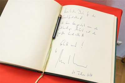 Bei seinem Besuch im Erzgebirgsmuseum trägt sich Sachsens Ministerpräsident Michael Kretschmer auch ins Gästebuch des Museums ein.