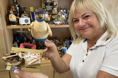 Beate Kummer kümmert sich seit 30 Jahren um die Kundengeschenke der Firma. Holzmännle, die von der Firma Holzkunst Kuhnert Rothenkirchen speziell auf die Wünsche der Kummers hin produziert werden. In der Hand hält Beate Kummer die Jubiläumsausgabe.