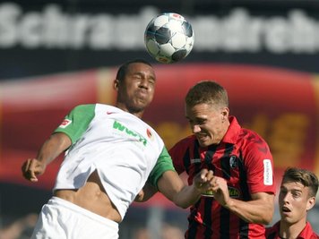             Der Augsburger Ohis Felix Uduokhai (l) und Nils Petersen vom SC Freiburg gegen zum Ball.