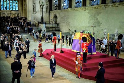 Menschen gehen am Sarg von Königin Elizabeth II. vorbei, der mit der königlichen Standarte geschmückt ist. 
