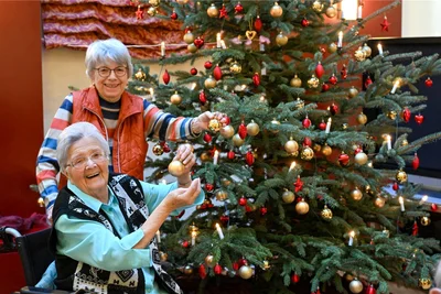 Helga Ebert (vorn) und Brigitte Leipart am Weihnachtsbaum in der großen Lobby des Seniorenzentrums. Krieg prägte diese Generation und damit auch Erinnerungen.