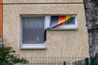 Wenige Meter neben der Fassadenmalerei, die an die Gräueltaten des NSU erinnern, hängt demonstrativ eine Deutschland Fahne aus einem Fenster im Plattenbau-Wohngebiet "Fritz Heckert".