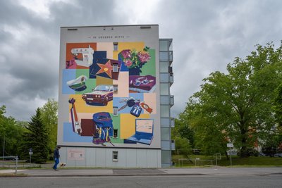 Fassadenbild mit dem Titel "- In unserer Mitte -" am Gebäude eines Mehrfamilienhauses an der Friedrich-Viertel-Straße im Fritz Heckert-Wohngebiet.