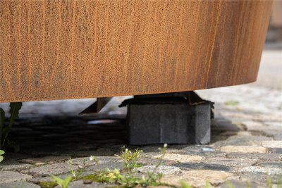 Weil die Pflanzkübel halb auf dem Fußweg stehen, musste der Unterschied mit Steinen ausgeglichen werden.