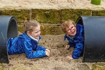 Da bin ich! Krabbeln, Robben, Verstecken, Bemalen: Die Kriechrohre werden von den "Kleinen Weltentdeckern" in Stolpen intensiv und abwechslungsreich bespielt. Der Hang dahinter wurde mit Sandsteinmauern terrassiert und damit auf verschiedenen Ebenen nutzbar gemacht.