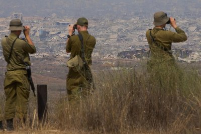 Israelische Soldaten beobachten von Südisrael aus zerstörte Gebäude im Gazastreifen. Inzwischen gibt es Hoffnungen für eine neue Waffenruhe in dem Kriegsgebiet.