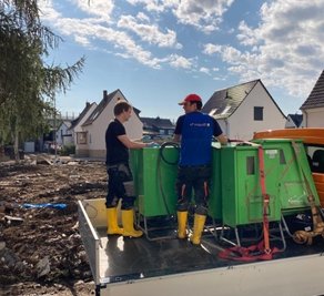 Helfer bringen Stromverteilerkästen, um vor Ort eine provisorische Energieversorgung aufzubauen.