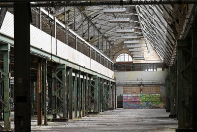 Blick in eine der großen Fertigungshallen. Ein Objektbetreuer kümmert sich um die leer stehenden, weit über 100 Meter langen Gebäude.
