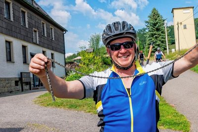 Kette gerissen: Thomas Schurig, Bürgermeister von Dorfchemnitz, hat zu kräftig getreten. Seine Frau bringt ein Ersatzrad.
