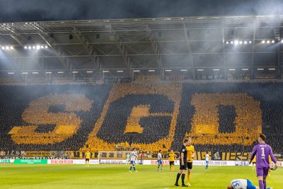 K-Block-Choreografie mit schwarzen und gelben Regenponchos – deren Einsatz der Dresdner Fanszene von der Berliner Polizei beim Heimspiel gegen Dynamo im Herbst 2025 noch aus Brandschutzgründen untersagt worden sein soll.