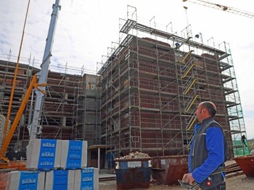 Mirko Große von der ortsansässigen Baufirma Voitel dirigiert per Fernbedienung den Baukran am ehemaligen Kaufhaus Schocken. 