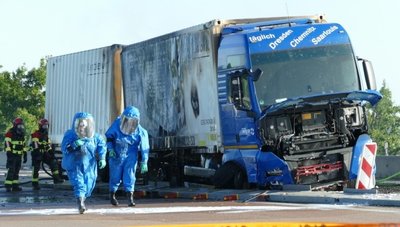 Einsatzkräfte in Schutzanzügen vor dem verunfallten Gefahrgut-Laster auf der A 14 in der Nähe von Leisnig.